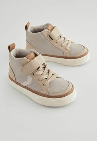 Beige höga sneakers med snörning och kardborreknäppning, med ett mjukt yttermaterial, kontrasterande bruna detaljer och strukturerad gummisula.