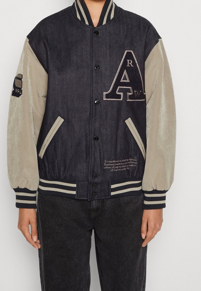 Jeansjacka i mjuk beige tyg med ribbad krage och manschetter, har logotyp och broderade detaljer på bröstet och ärmen.