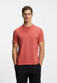 Short-sleeve, coral shirt in soft fabric with a crew neckline. Features a small "BOSS" logo on the left chest. Straight hem.