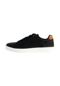 Zapatillas bajas negras con parte superior lisa, suela de goma blanca y acento marrón en el talón. Presenta seis ojetes y una marca sutil.