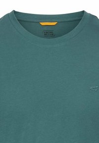 Teal bomulds T-shirt med rund halsudskæring, der har et lille broderet logo på brystet og et kontrastfyldt gult mærke indeni kraven.