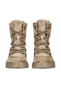 Botas de tobillo de ante beige con punteras redondas, que cuentan con ojales en tono dorado y cordones grises. Suelas de goma gruesa para tracción y durabilidad.