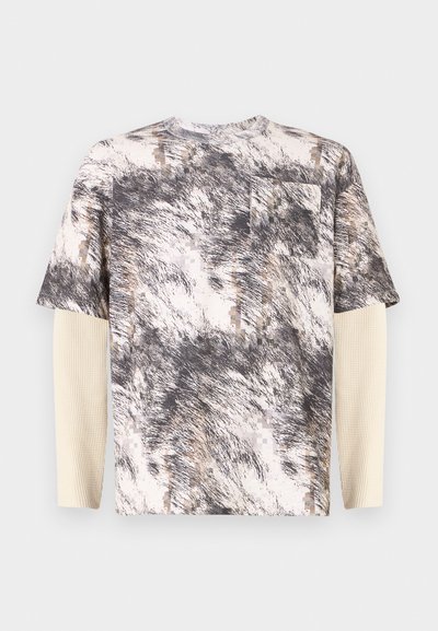 T-skjorte med kort erm med et teksturert grått og beige abstrakt mønster, med en brystlomme og lagde lange ermer i ribbet tekstur.