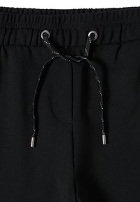 Schwarze Jogginghose mit einem elastischen Bund, ausgestattet mit einem Kordelzug mit reflektierenden Akzenten und einer kleinen Seitentasche. Glatte Stoffstruktur.