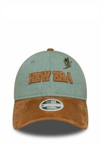 Blaues Denim-Cap mit braunem Wildleder-Schild; verfügt über ein gesticktes "NEW ERA"-Logo und eine stiefelförmige Pin-Akzentuierung. Verstellbarer Riemen hinten.