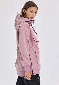 Rosa Kapuzenjacke mit einer Fronttasche, seitlichen Reißverschlüssen und Kordelzug. Weiches Material, lockere Passform und gerippte Bündchen.