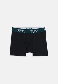 Boxer da uomo neri con elastico verde scuro, caratterizzati da un motivo ripetuto del logo Puma bianco, stesi su uno sfondo bianco.