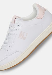 White synthetic leather sneaker with pink accents, round toe, lace-up design, textured upper, and rubber outsole with a gum color.