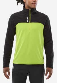 Green and black pullover with a quarter zipper, featuring a textured body and smooth black sleeves. "MILLET" logo on the chest.
