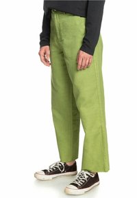 Gröna vida byxor i bomull med hög midja och mjuk textur. I kombination med svarta sneakers med vita detaljer.