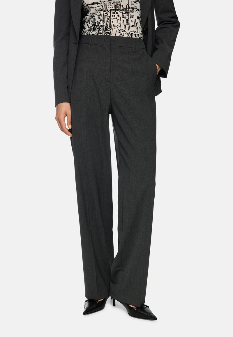 Gray tailored trousers with a straight fit, featuring a fine texture. Paired with a patterned top and pointed black heels.
