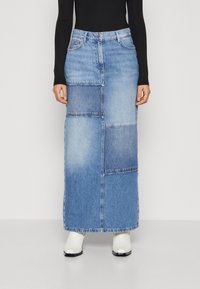 Denim maxi szoknya foltvarrásos mintával világos és sötétkék árnyalatokban. Jellemzője a derékgomb, övhurkok és egyenes szabás.