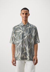 Short-sleeved shirt in light gray fabric with a bamboo pattern in blue and gold, featuring a pointed collar and button front.