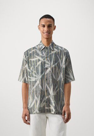 Short-sleeved shirt in light gray fabric with a bamboo pattern in blue and gold, featuring a pointed collar and button front.