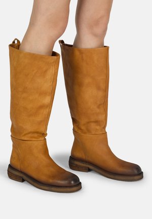 Bruine lederen laarzen tot de knie met een iets slouchy ontwerp, ronde neus en gestapelde hak. Textuurafwerking en trekstraps aan de bovenkant.