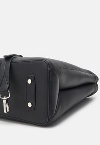 Sac à main en cuir noir à la forme structurée, doté de ferrures en argent, d'une bandoulière amovible et d'une surface texturée. Accents à finition lisse.