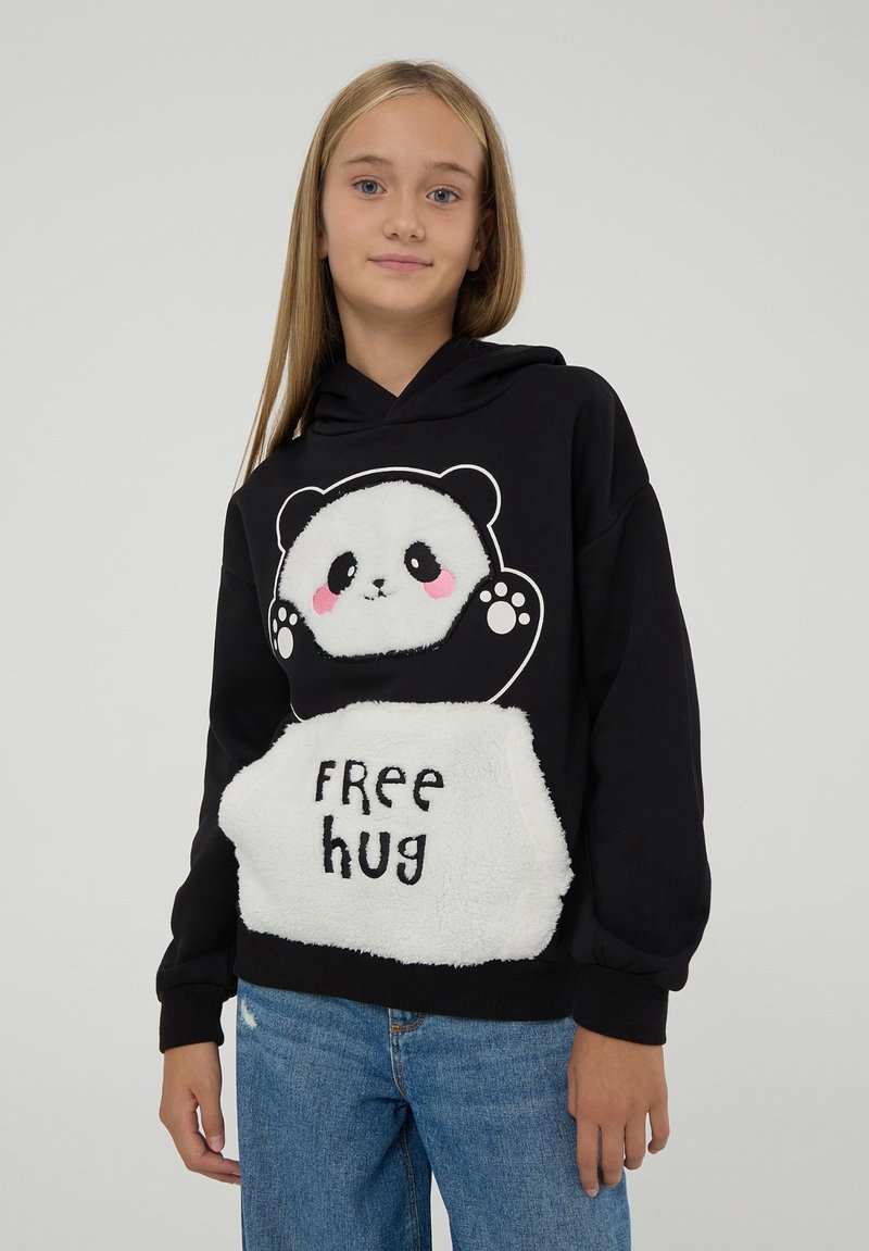 Czarna bluza z kapturem z grafiką pandy oraz napisem "Darmowy uścisk" na białej, puszystej kieszeni. Miękka tkanina, luźny krój, długie rękawy.