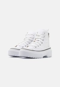 Adidași înalți albi din material textil, cu vârf rotund, talpă plată, ochiuri argintii și detalii cu fermoar pe lateral. Accente negre pe talpă.