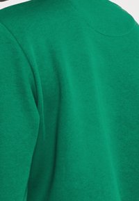 Groene sweatshirt met een zachte textuur, ronde halslijn en zichtbare naden op de schouders. Heeft een relaxte, oversized pasvorm.
