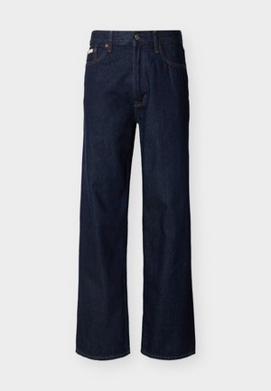 Σκούρο μπλε τζιν παντελόνι ίσιας γραμμής με πέντε τσέπες και κουμπί κλεισίματος, εμφανιζόμενο σε απλό φωτεινό φόντο.