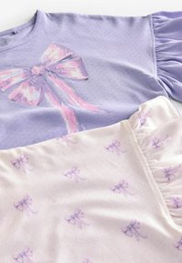 Lilac lyhythihainen paita, jossa on nauhakuosi, yhdistettynä kermanvärisiin alaosiin, joissa on pieniä vaaleanpunaisia nauhakuoseja ja rypytetty sivuyksityiskohta.