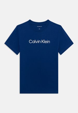 T-shirt en coton bleu avec un col rond, à manches courtes, arborant le logo « Calvin Klein » imprimé en blanc sur la poitrine.