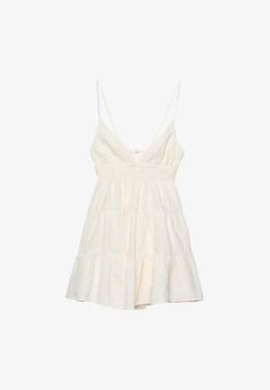 Robe d'été légère en crème avec des bretelles spaghetti fines, un décolleté en V profond, une taille smockée et une jupe à volants superposés. Fabriquée à partir d'un mélange de coton texturé.