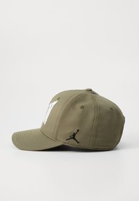 Căciulă de baseball verde-oliv cu litere albe și logo-ul Jordan brodat în negru, design structurat, vizieră curbată și șase ochiuri de ventilație.
