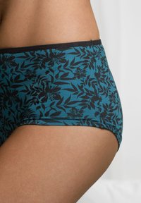 Mutande in cotone turchese con un motivo floreale nero, dotate di una vita morbida e di una texture liscia. Cuciture dettagliate lungo i bordi.