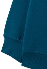 Teal sweatshirtmanchetten met ribbelstructuur. Glad stof, losse pasvorm en afgedichte naden voor duurzaamheid.