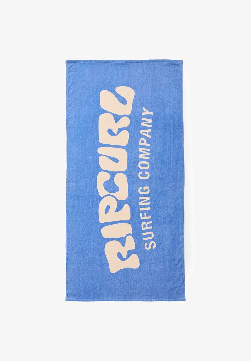Blåt strandhåndklæde med stor beige tekst "RIP CURL" og mindre vertikal tekst "SURFING COMPANY" på en hvid baggrund.