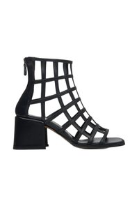 Black open-toe ankle boot with a grid design. Made from leather, features a block heel and a zipper on the back for closure.