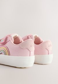 Ružové tenisky s hladkým syntetickým vrchom s multicolor dúhovým dizajnom a bielou gumovou podrážkou. Doplnkové semišové pätky.