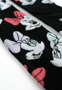 Calzini neri con personaggi dei cartoni animati colorati, dotati di distintivi fiocchi in rosa, viola e azzurro, che mostrano una trama e dei motivi lavorati a maglia.