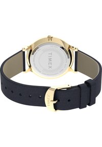 Reloj Timex con caja de acero inoxidable dorado, esfera blanca y correa de cuero texturizado azul marino. Presenta un cierre de hebilla y es resistente al agua.