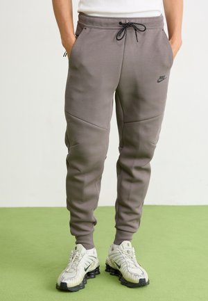 Gray Nike sweatpants made of soft fabric, featuring a drawstring waistband, side pockets, and a sleek tapered design.