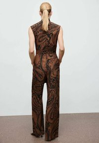 Mono marrón con estampado de paisley de diseño ajustado, top sin mangas, piernas anchas y cuello alto, hecho de una tela suave.