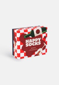 Darovaná krabička s červenobielym károvaným vzorom, na ktorej je grafika fľaše vína a pohárov. Navrhnutá pre dva páry dospelých ponožiek s nápisom "HAPPY SOCKS".