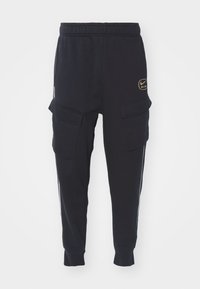 Czarne spodnie dresowe z elastycznym pasem, bocznymi kieszeniami cargo, białymi paskami po bokach i złotym logo Nike Air z przodu. Miękka tekstura, dopasowany krój.