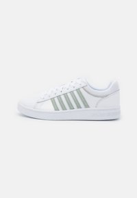Sneakers bianchi con tre strisce verde chiaro, parte superiore in sintetico liscio, punta arrotondata, design classico con lacci e suola in gomma testurizzata.