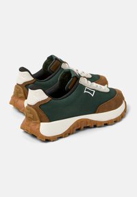 Gröna sneakers med ett texturerat tygöverdel, bruna mockadetaljer, vita snören och en robust gummisula med ett mönster för bra grepp.