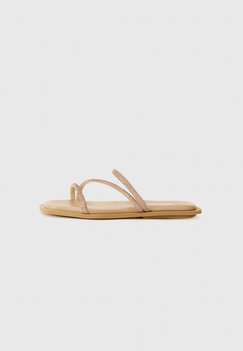 Flat sandal with two narrow, rose-gold textured straps. Features a smooth, tan footbed and slim rubber sole. Minimalist design.