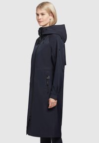 Mornarska nepromočiva kišna jakna s kapuljačom, prednjim patentnim zatvaračem, dva bočna džepa, podesivim špagama i elegantnom siluetom.