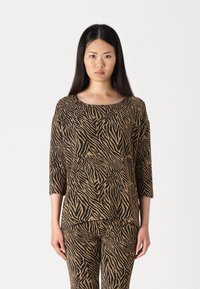 Brun och svart zebra-randig topp med trekvartslånga ärmar, med rund halsringning och lös passform, i kombination med matchande byxor.