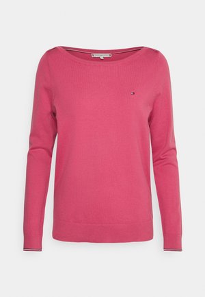 Maglione rosa a maglia con scollatura ampia e maniche lunghe. Presenta un piccolo logo sul petto e dettagli a righe nei polsini.