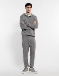 Grå huvtröja med avslappnad passform och framficka, i kombination med matchande tapered sweatpants. Båda tillverkade av mjuk, strukturerad tyg.