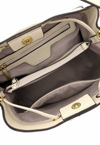 Beige leather handbag interior with multiple compartments, including a zippered pocket. Features gold hardware and a smooth texture.