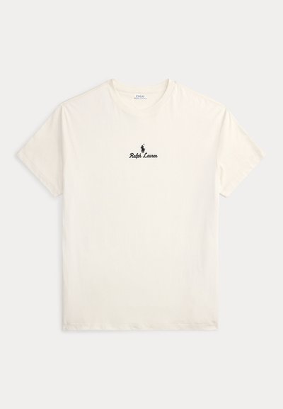 Krémově zbarvené tričko s krátkým rukávem s logem a textem Ralph Lauren uprostřed na hrudi, položeno na světlém pozadí.