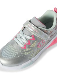 Silberner Sportschuh mit Mesh-Seiten, pinken Akzenten, verstellbarem Riemen und strukturiertem Sohlen. Reflektierendes Material verbessert die Sichtbarkeit.