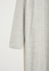 Cardigan gris en maille avec une coupe ample, des manches longues et une texture douce, avec des lignes épurées et des détails minimaux.